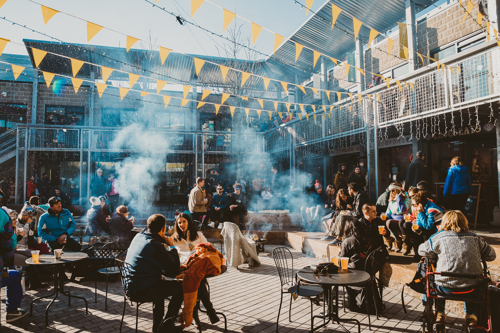People sitting at dining tables with fireplaces in Bow Market